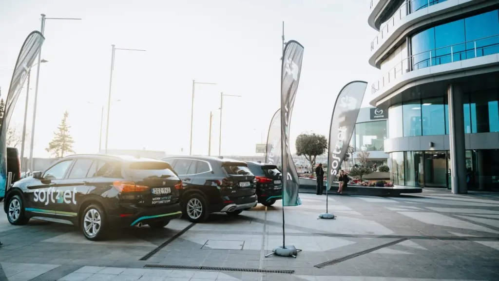 Företagsbilar parkerade utanför kontoret med Soft2Bet-logotyp i Sverige